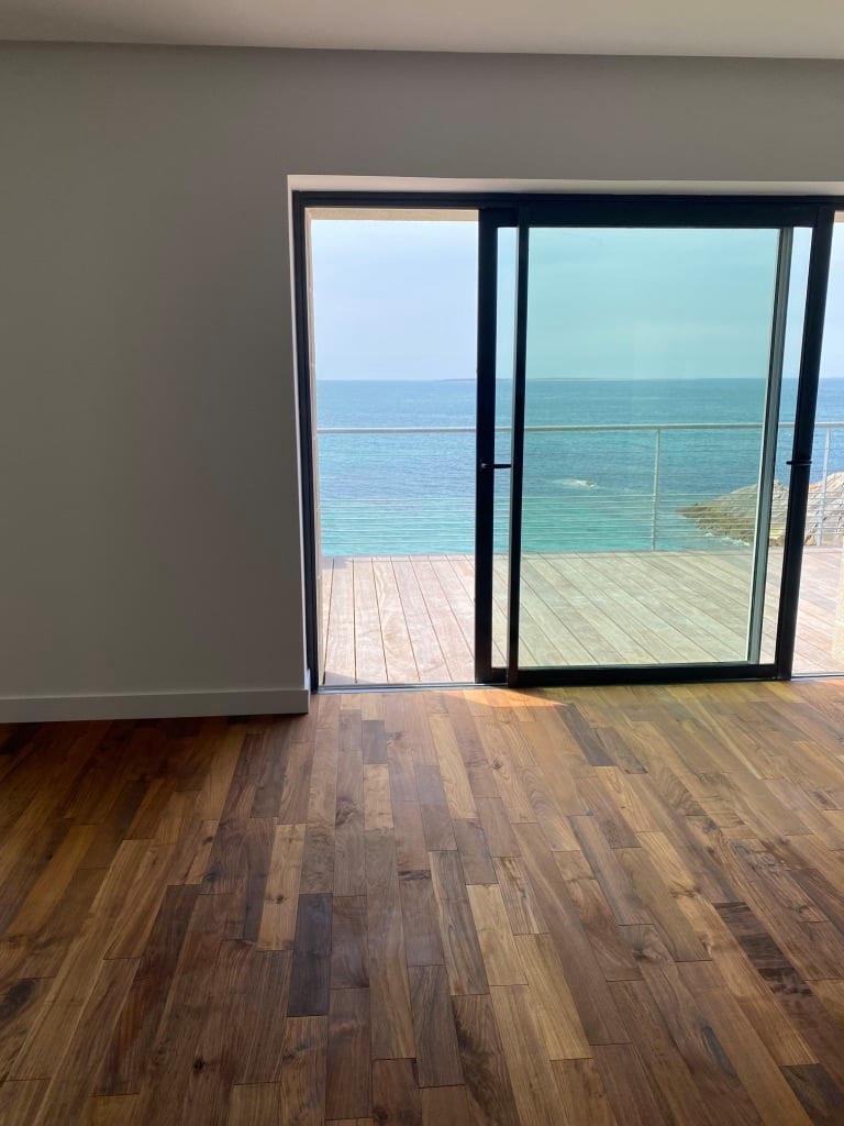 Pièce de vie avec parquet face à la mer